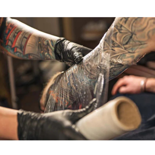 Tattoo being wrapped with plastic for healing
